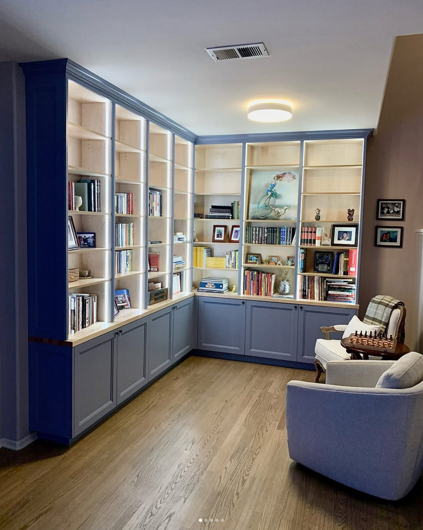 Built-in shelves with dark blue lower cabinets and frame, topped with glass-door showcases.