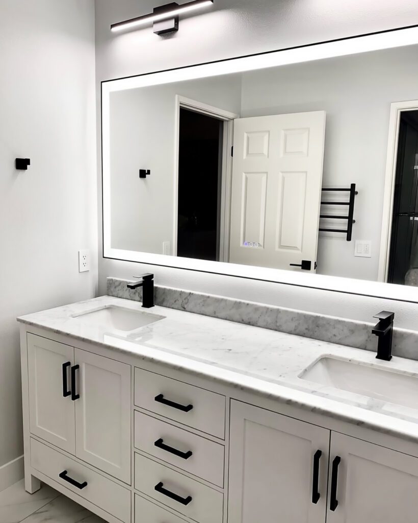 white bathroom cabinets and sinks with black faucets, remodeling made by OK Construction and Remodeling