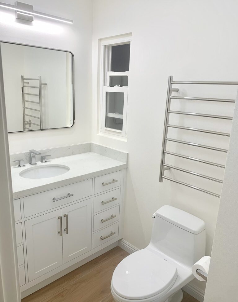 white bathroom: counter with one sink, mirror and white drawers